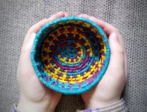 A coil basket made of rope and yarn, similar to the one participants will craft at the coil basket workshop at Vision Martial Arts